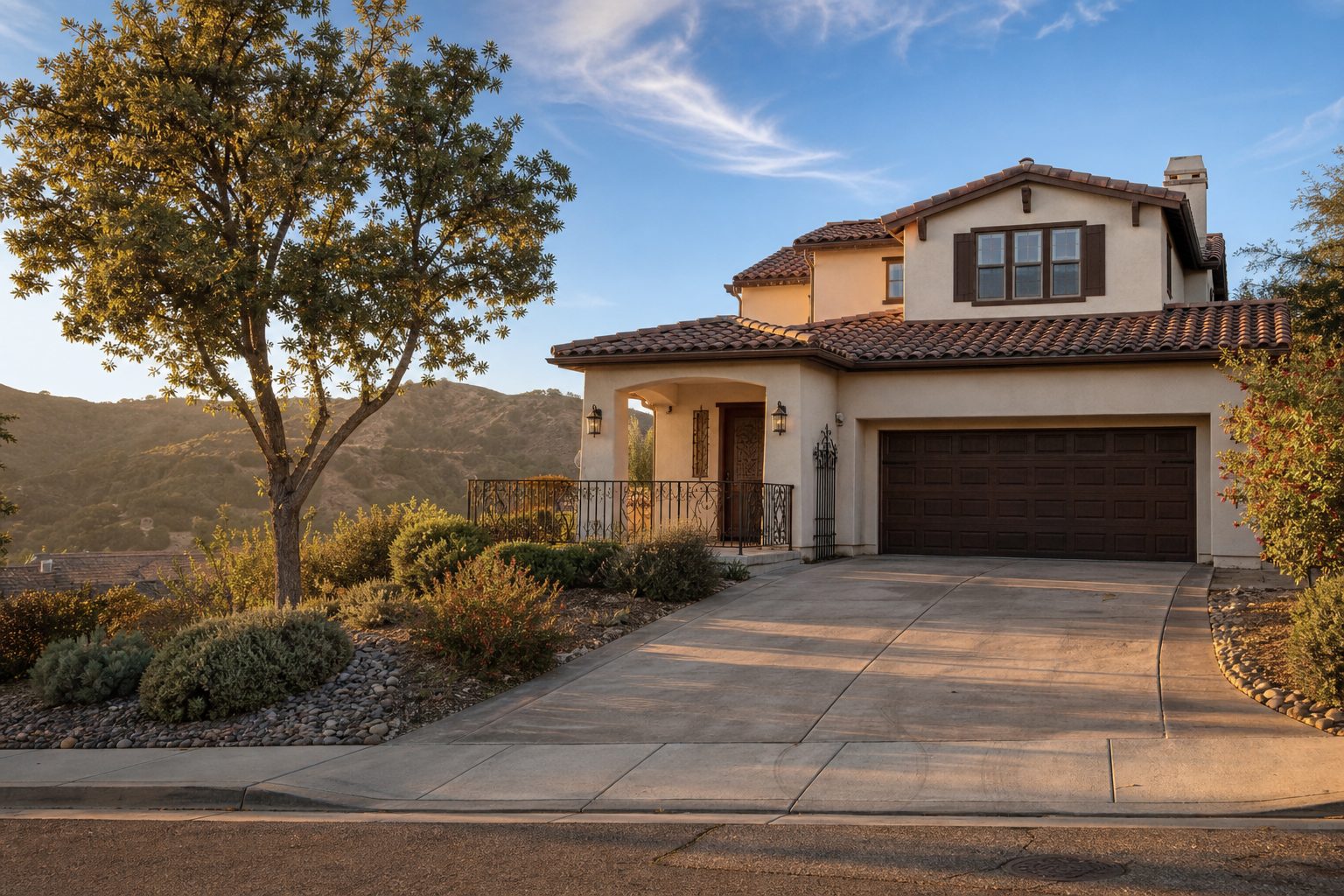 Mediterranean-style two-story foothill home in Deer Creek with oak trees and native landscaping in morning sunlight.
