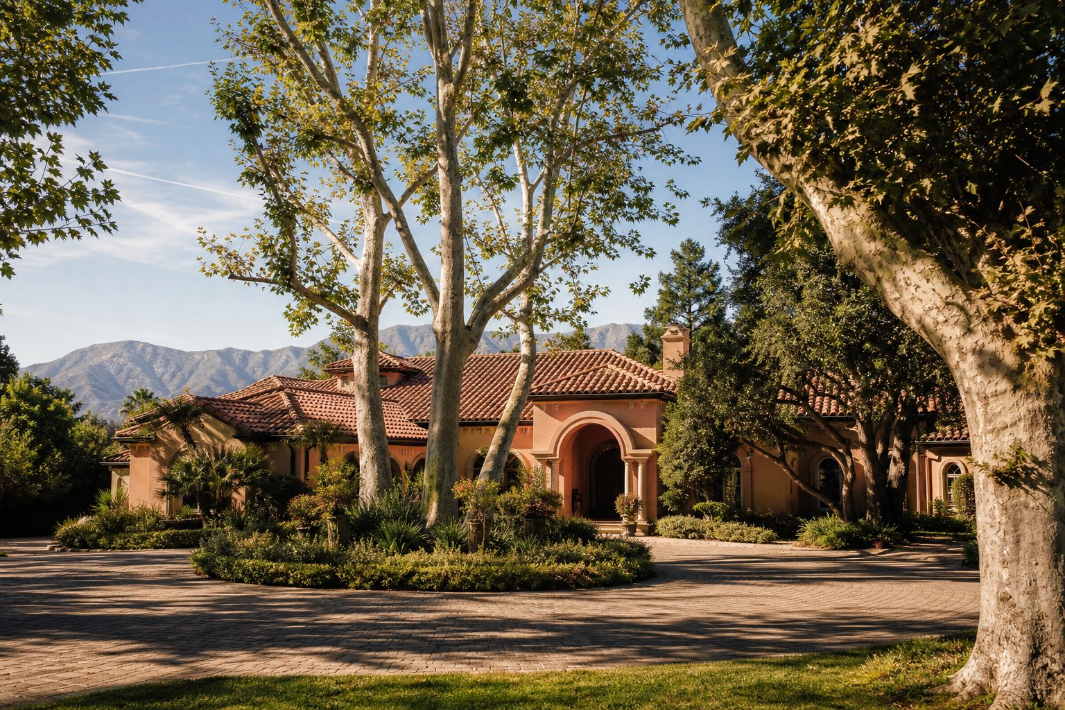 Mediterranean-style Alta Loma home with mature trees, large corner lot, and established neighborhood character in morning light.
