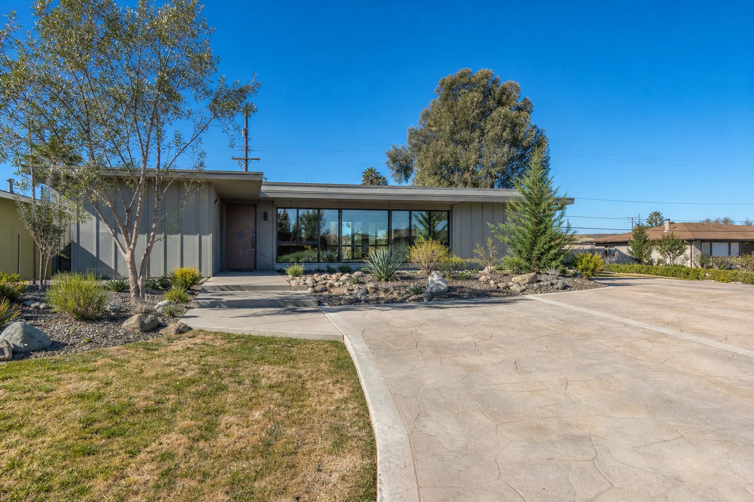 Contemporary ranch home with board-and-batten siding and updated landscaping in central Rancho Cucamonga neighborhood.