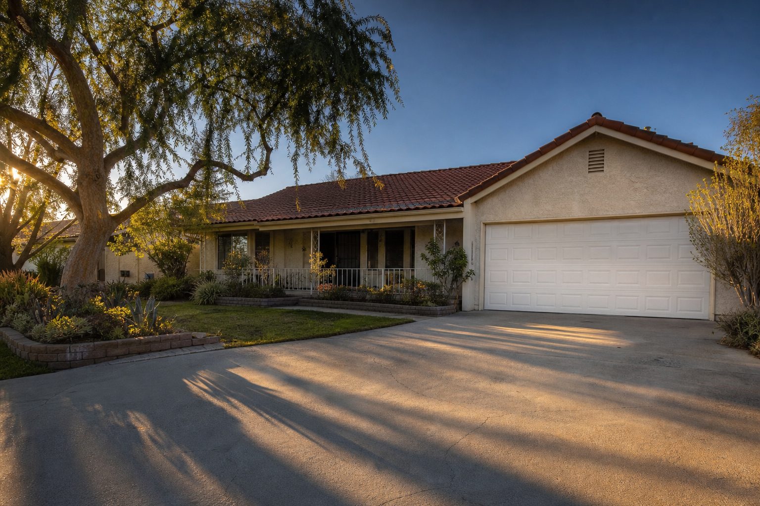 Ranch home with driveway and mature pepper tree in established Rancho Cucamonga neighborhood at golden hour.