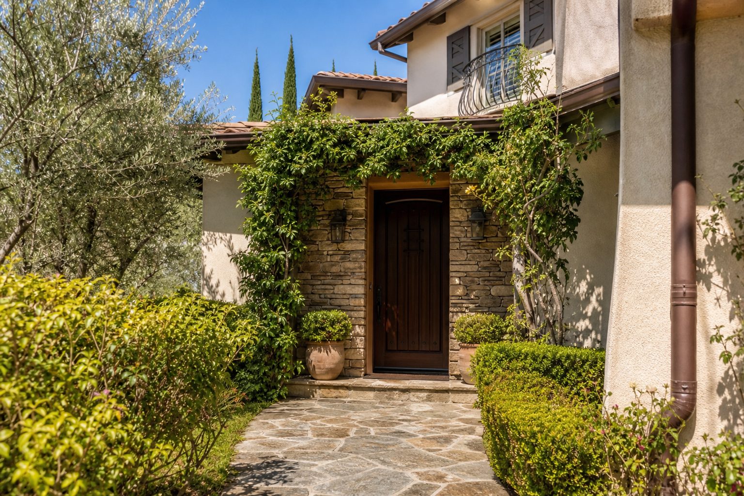 Upgraded entry detail of Rancho Cucamonga home with stone veneer, mature plantings, and established landscaping.