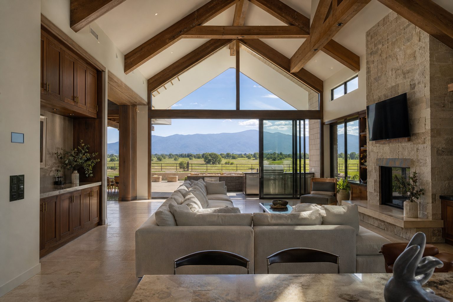 Open-concept custom home interior in Alta Loma showing imported stone finishes, whole-home automation, and mountain pasture views through glass walls.