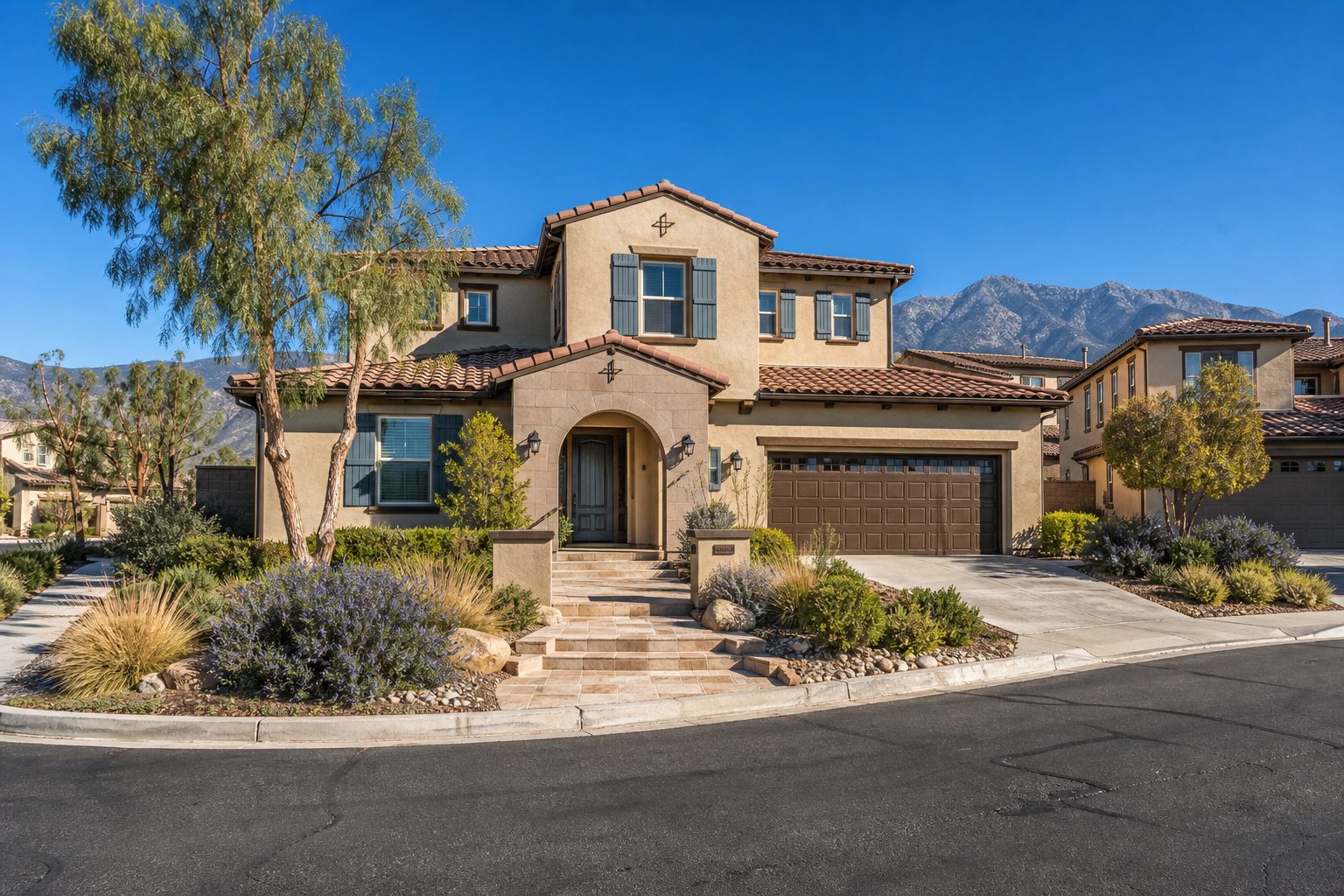Two-story Rancho Cucamonga home with Spanish tile roof, stucco exterior, and desert landscaping in residential neighborhood.