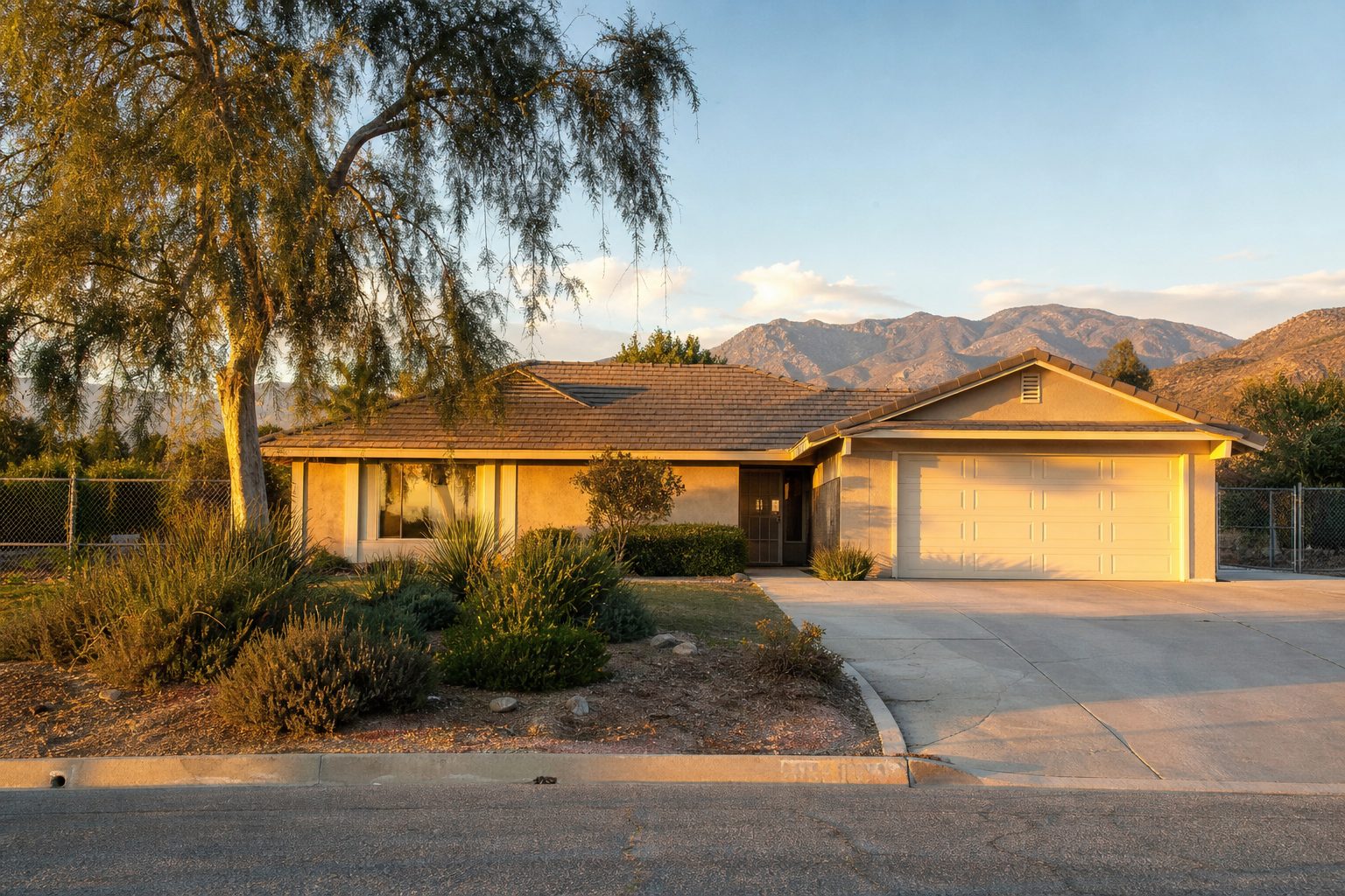 Single-story ranch home with mature pepper tree and drought-resistant landscaping at sunset in Rancho Cucamonga.