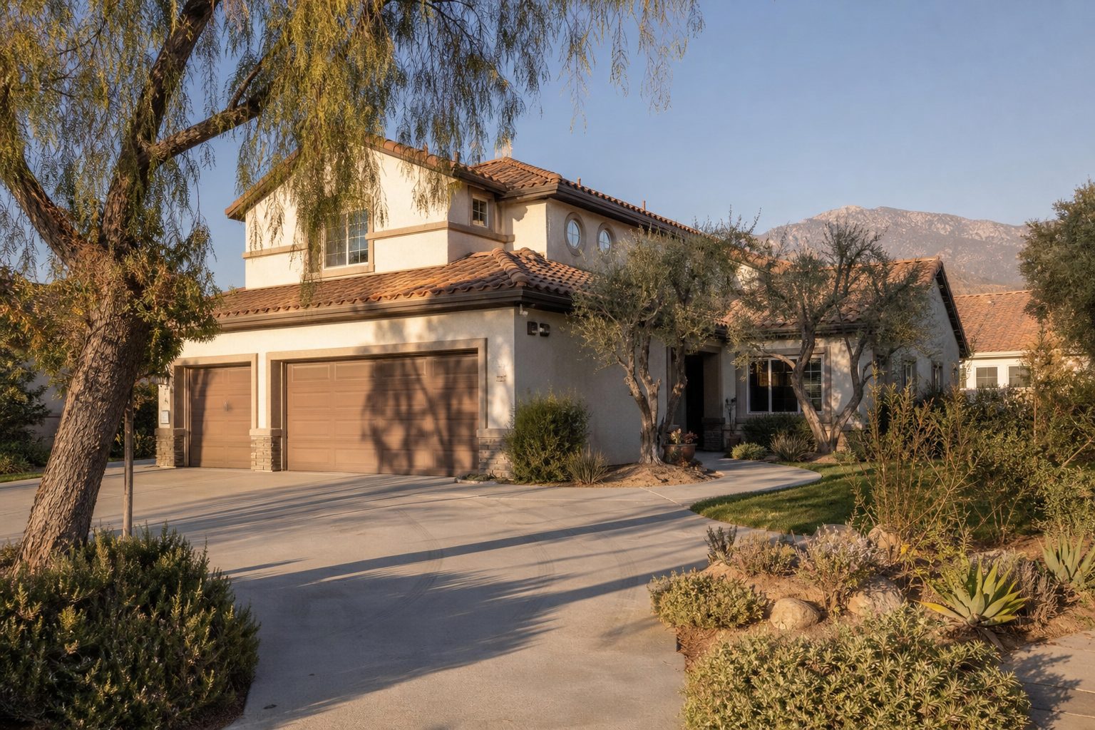 Two-story stucco home with terracotta roof and mature pepper trees in a Rancho Cucamonga residential neighborhood.