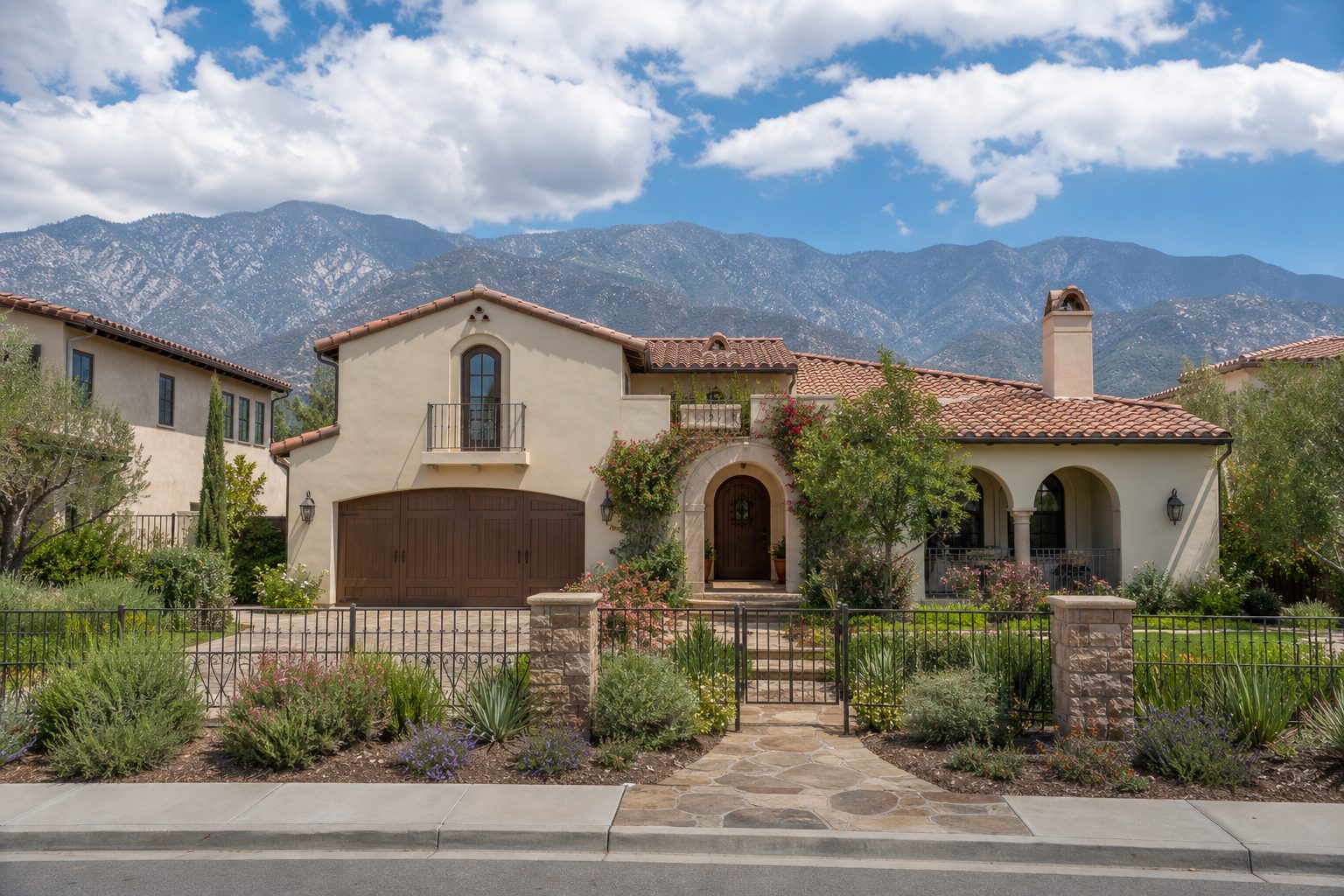 Mediterranean-style Rancho Cucamonga home with arched entry and native California landscaping under blue sky.