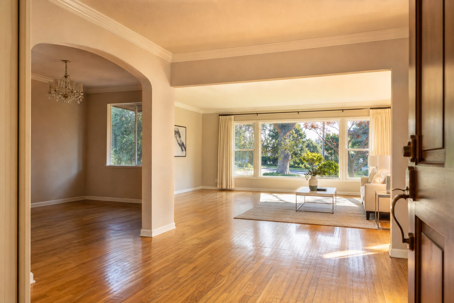 Vacant estate home interior with hardwood floors, arched doorways, and natural window light in central Rancho Cucamonga.
