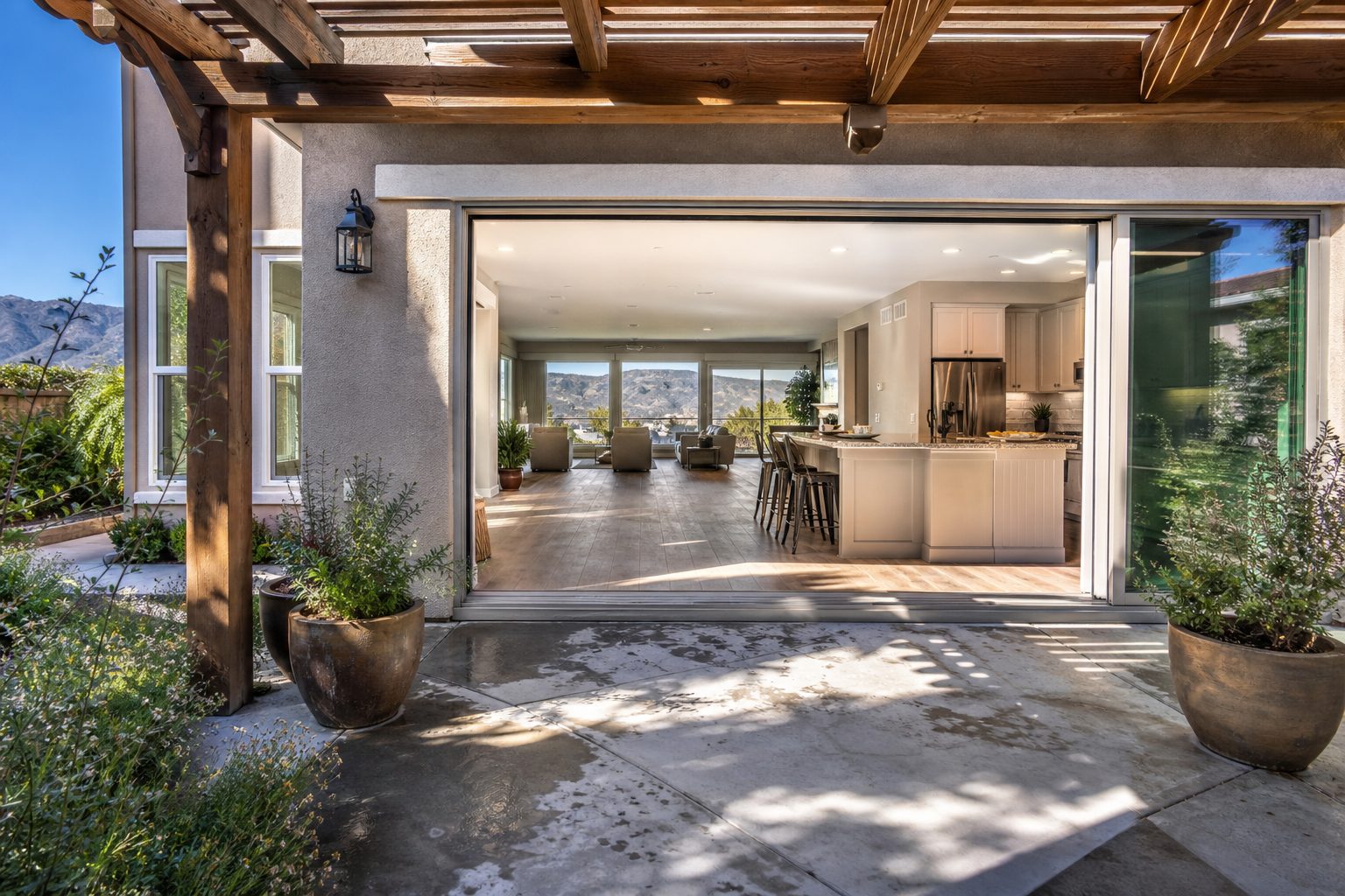 Terra Vista home's covered patio and updated kitchen interior framed by pergola and native plantings in Rancho Cucamonga.